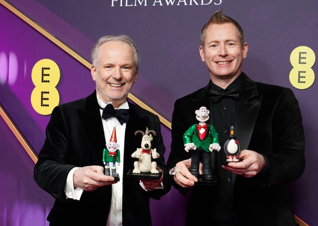 Nick Park and Merlin Crossingham, holding characters from Wallace And Gromit, at the Baftas 