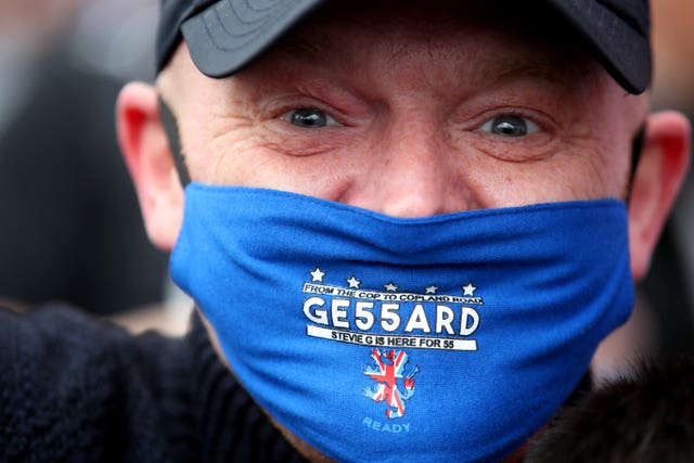 A Rangers fan wears a celebratory face mask 