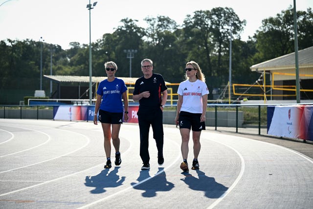 Prime Minister Sir Keir Starmer walks on a track and speaks with Team GB’s team manager for athletics Pamela Robson (left) and head of preparations Maria Adey (right) at a training centre in Saint-Germain-en-Laye