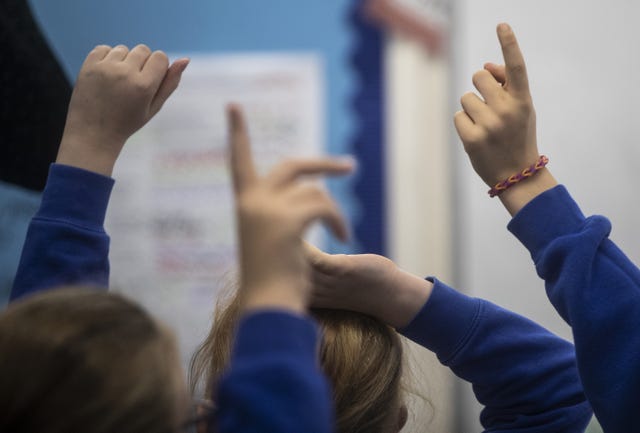 School children with their hands raised