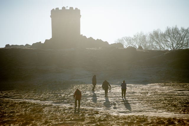 Walkers approach Old John Tower at Bradgate Park in Leicester, on a cold and bright morning across the Midlands 