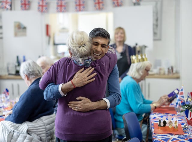 Prime Minister Rishi Sunak hugs a member of a community group’s lunch club at Mill End Community Centre, Rickmansworth, after helping to prepare and serve food and drinks , as part of the Big Help Out