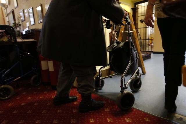 An elderly person with their walker at a charity tea party in London.
