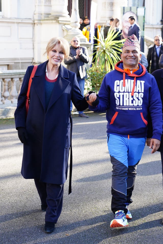 Dame Joanna Lumley holding hands with Sujan Katuwal outside the Embassy Of Nepal