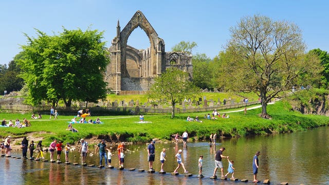 Venturing across the stepping stones at Bolton Abbey in North Yorkshire