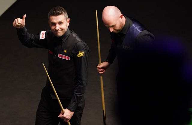 Mark Selby, left, celebrates with a thumbs up to fans after beating Matthew Selt, right