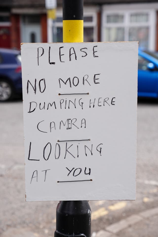A sign on a lamppost in the Sparkhill area of Birmingham that reads 'please no more dumping here, camera looking at you'