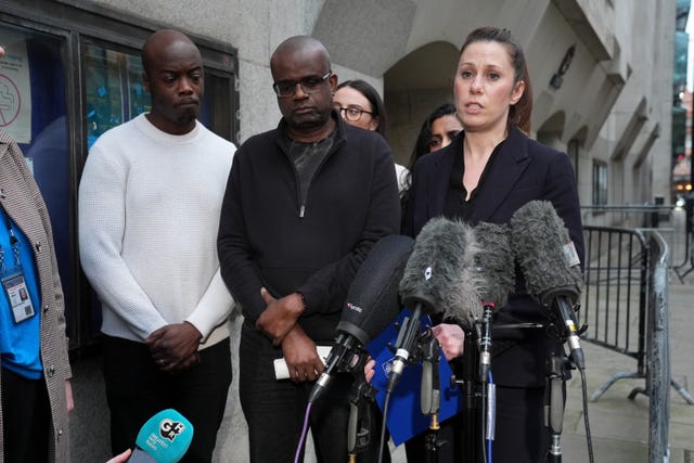 Michael Andam speaking into microphones alongside family and DCI Becky Woodsford