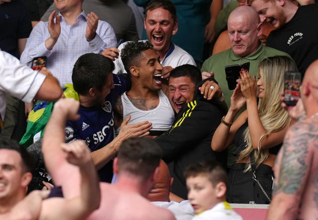 Raphinha celebrates Leeds' survival in the stands with the fans 