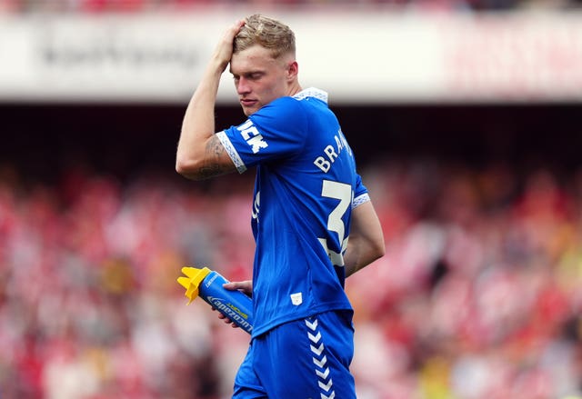 Everton defender Jarrad Branthwaite brushes his hair to one side while holding a Lucozade bottle