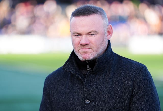 Former England captain Wayne Rooney at pitchside on commentary duty.