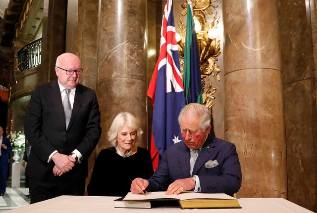 The Prince of Wales and Duchess of Cornwall sign the 100-year-old guest book at Australia House 