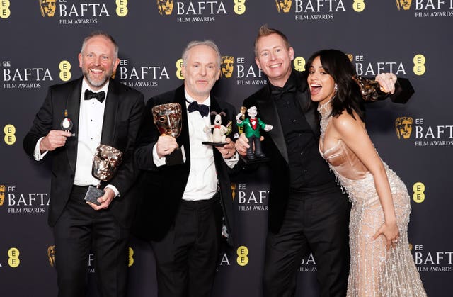 Camila Cabello presents Nick Park, Merlin Crossingham and Richard Beek with the best children’s & family film award for Wallace & Gromit: Vengeance Most Fowl in the press room during the 78th British Academy Film Awards at the Royal Festival Hall, Southbank Centre, London