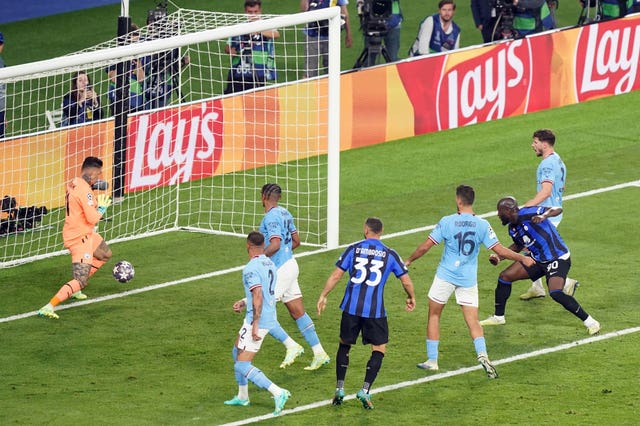Ederson, left, saves from Romelu Lukaku, second right, late on