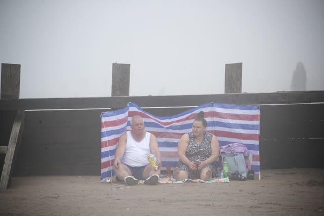 People on Edinburgh’s Portobello Beach surrounded by mist 