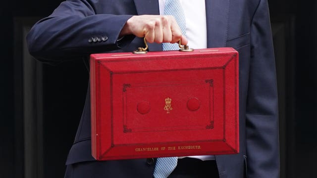 A hand holding a red ministerial box