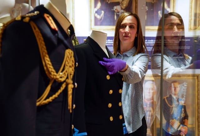 Kate Braun adjusts a naval Wren uniform which once belonged to the Princess Royal