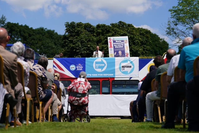Reform UK leader Nigel Farage speaking on top of a double-decker bus in Maidstone, Kent