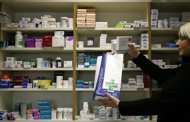 A pharmacist putting medication into a bag