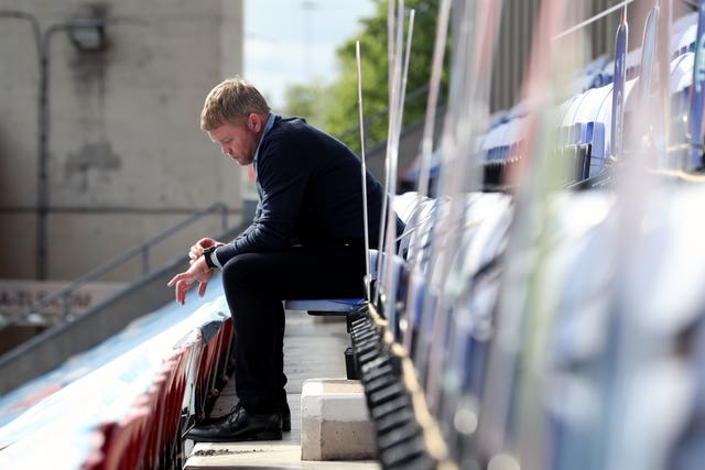Grant McCann sits alone in the stand at Wigan