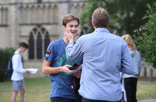 Ben Millett reacts with his father (back to the camera) as students at Norwich School receive their A-level results 