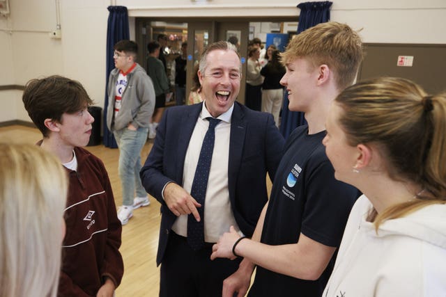 Paul Given (centre) joins students at Belfast High School as they receive their A-level results