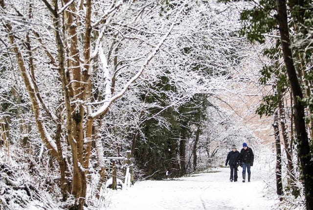 A couple walk through the snow in Auchendinny, Midlothian