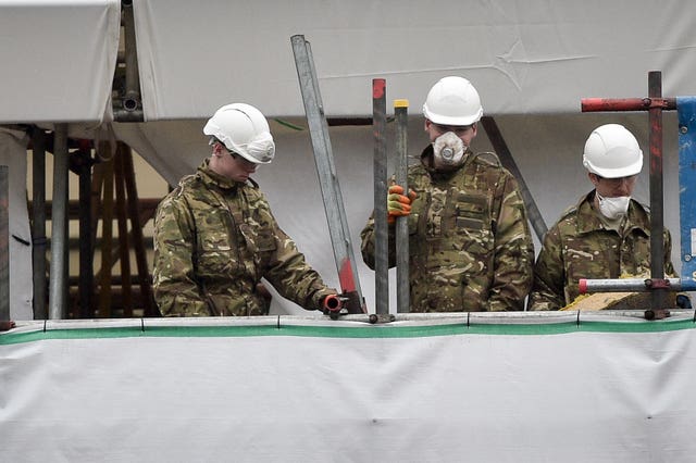 People dressed in British Army fatigues remove bricks and rubble from Sergei Skripal's house in Salisbury