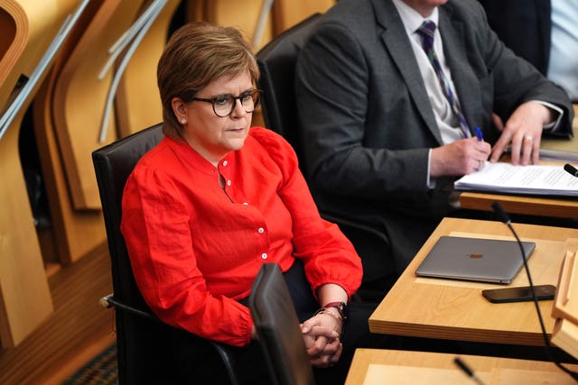 Nicola Sturgeon seated in Holyrood, wearing a red shirt