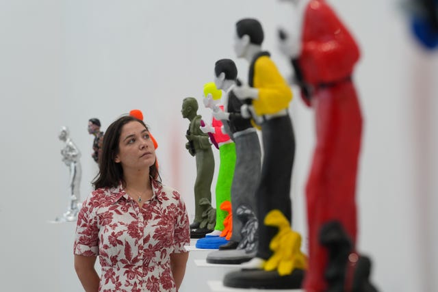 A woman inspecting Jack White's sculptures