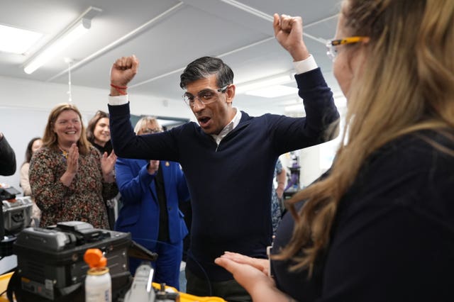 Rishi Sunak celebrates after being shown how to splice a wire at Wildanet Technical Training Academy in Liskeard