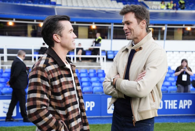 Wrexham co-owner Rob McElhenney, left, and Birmingham co-owner Tom Brady talk before a League One match