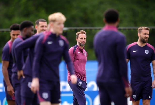 England manager Gareth Southgate stands amid players at a training session