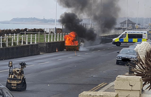 The explosive ordnance disposal team carrying out a controlled burn of desensitised chemicals in a skip near the sea wall in St Leonards