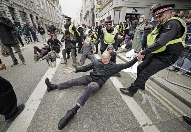 Police remove Extinction Rebellion protestors during the Lord Mayor’s parade in the City of London