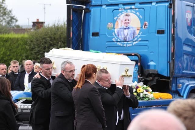Mourners carry the coffin of Ronan Wilson