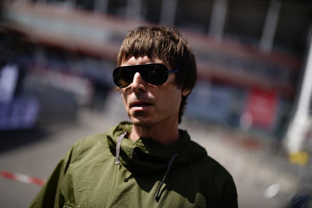 A Liam Gallagher lookalike wearing sunglasses and a green parka