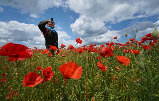 Melvyn Dunn, 77, from Ackworth, West Yorkshire, salutes in a field of poppies at the British Normandy Memorial site in Ver-sur-Mer 