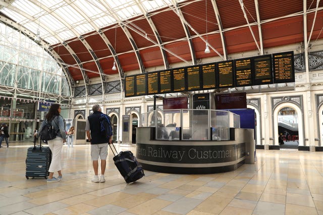 Passengers at Paddington station in London, as members of the Rail, Maritime and Transpo