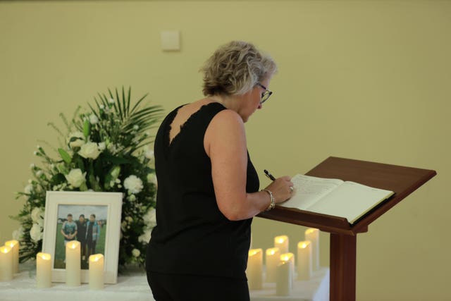 A woman signs a book of condolence