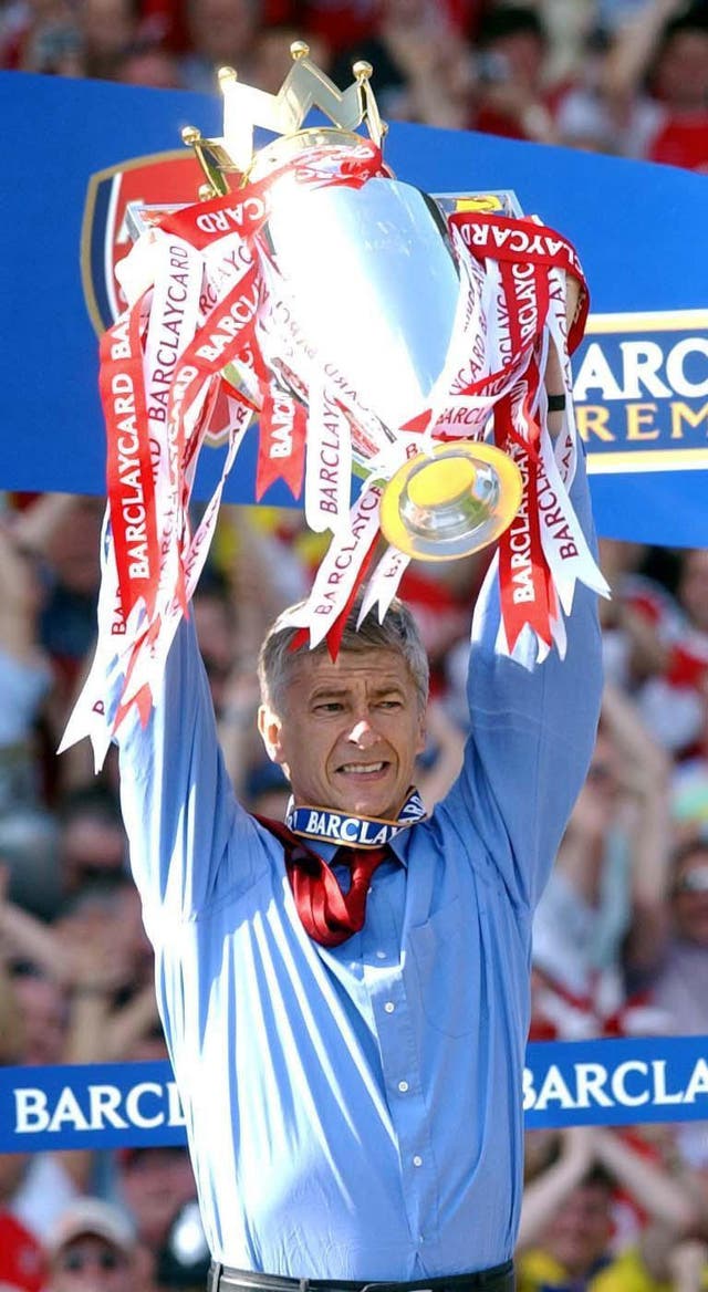 Arsene Wenger holds aloft the Premier League trophy after Arsenal's unbeaten season