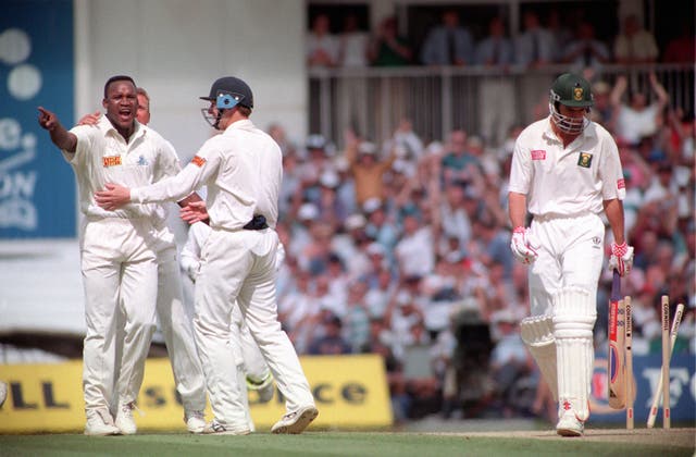 England’s Devon Malcolm, left, celebrates with team-mates as South Africa’s Hansie Cronje, right, leaves the field with his wicket rearranged