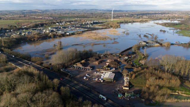 Cars driving on a road past flooded fields