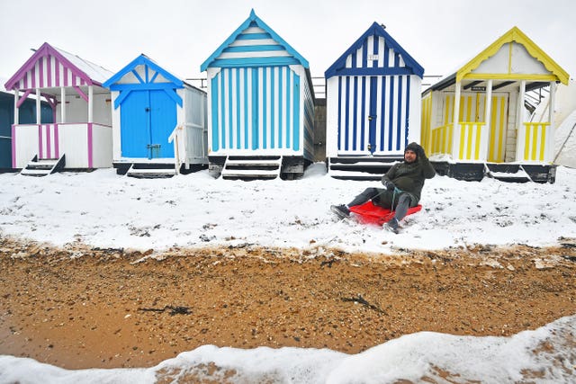 Beach huts next to a snow-covered beach in Essex