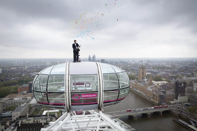 Sunny Jouhal, general manager of the lastminute.com London Eye, stands on top of a London Eye Pod, 135 meters high above the ground to celebrate the re-opening of the attraction (Matt Alexander/PA)
