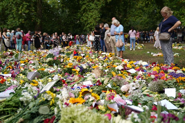 Members of the public view floral tributes in Green Park, near Buckingham Palace