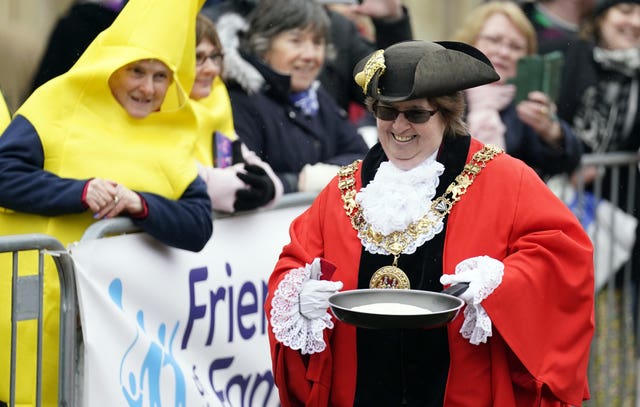 The Mayor of Winchester, Cllr Vivian Achwal, takes part in the Shrove Tuesday pancake race at Winchester Cathedral 