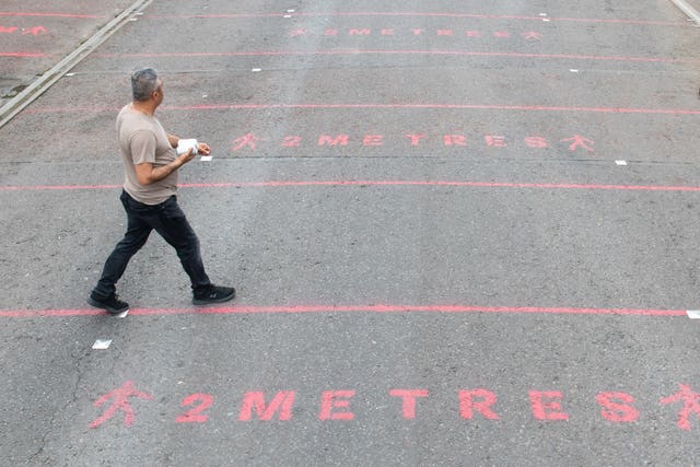 People walk over two metre social distancing markings