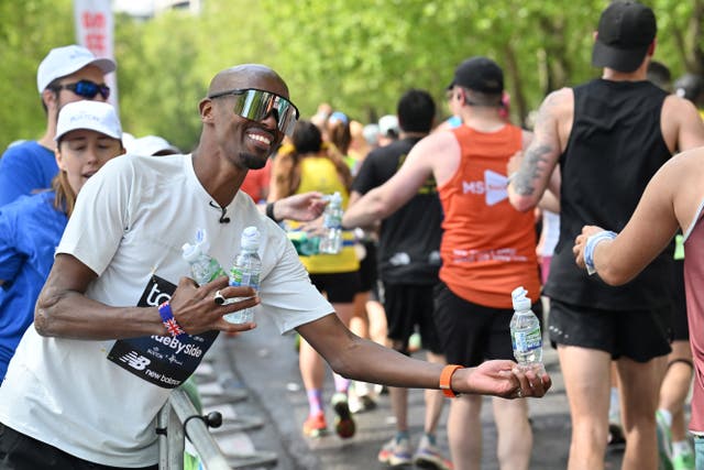 Olympic champion runner Mo Farah handed out bottles of water on The Embankment