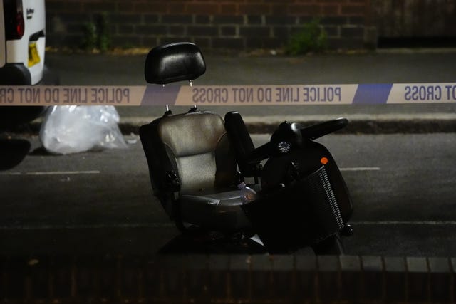 A mobility scooter on a street with police tape in the foreground